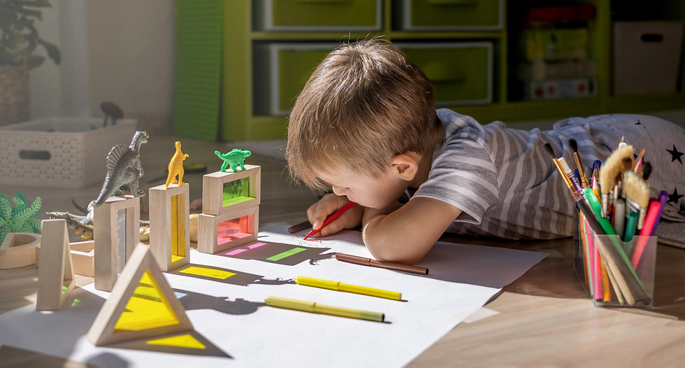 A cute little boy draws on the floor of