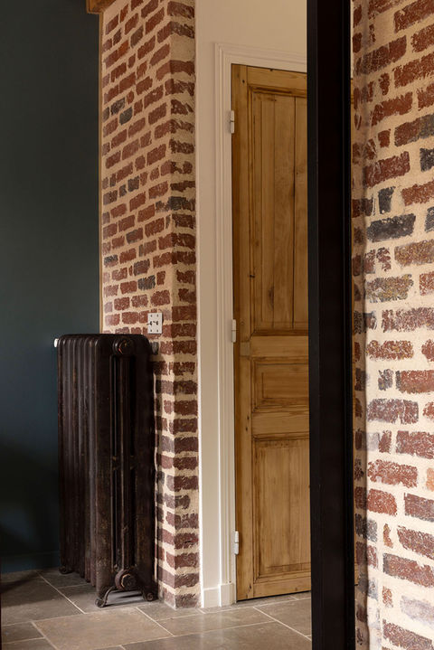 BIFUR Architecture - Détail de matières naturelles et contrastées dans le séjour : brique, bois, et fonte cirée