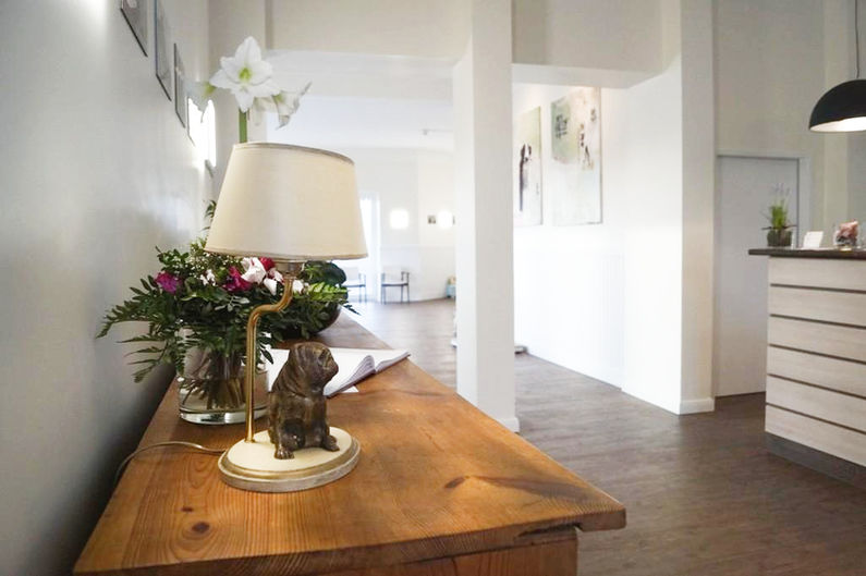 Holztisch mit Lampe und Blumen in einem hellen, modernen Eingangsbereich des TGZ