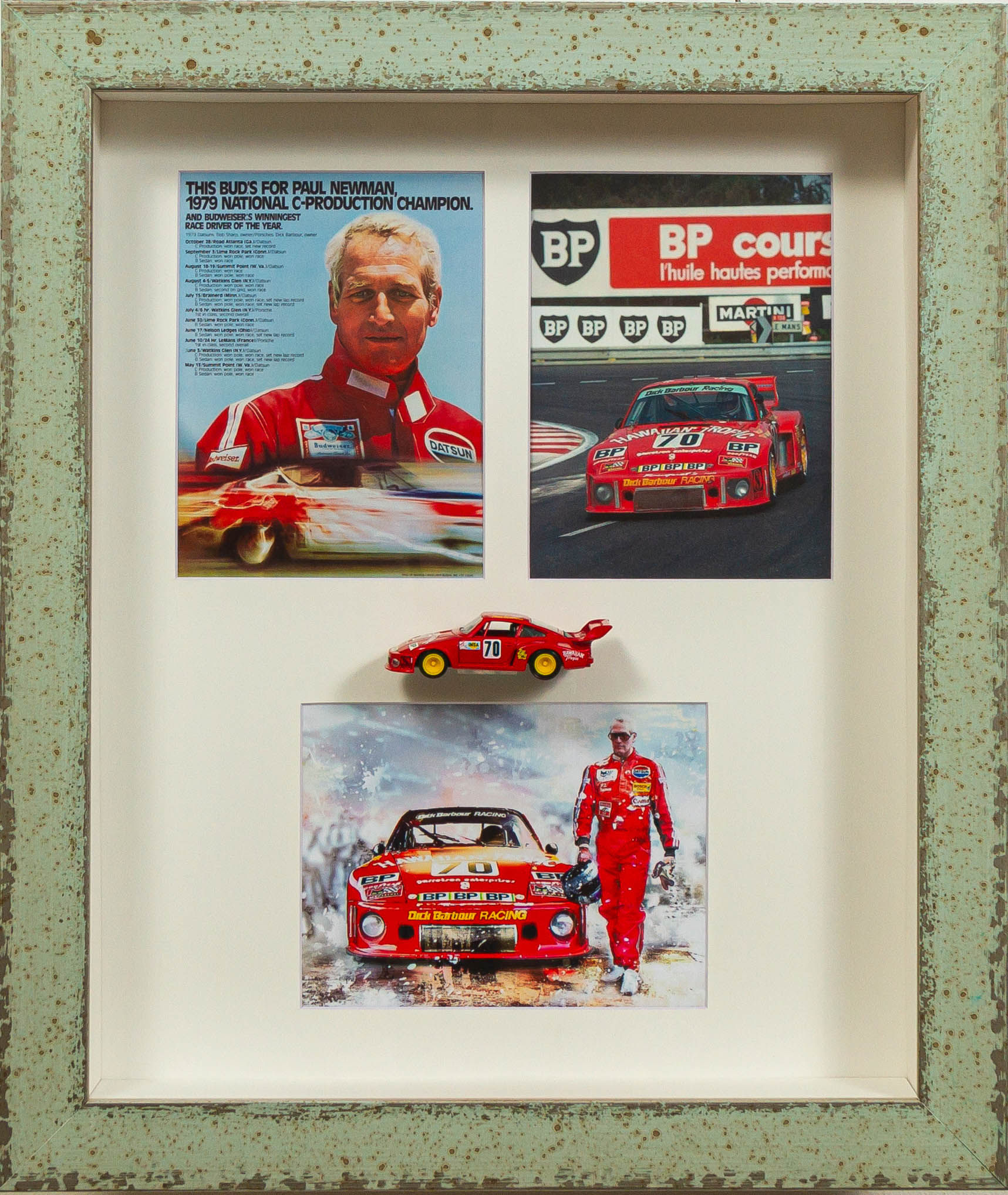 Framed Porsche 935 Paul Newman Diorama with red #70 diecast model and three vintage racing prints in distressed green frame.