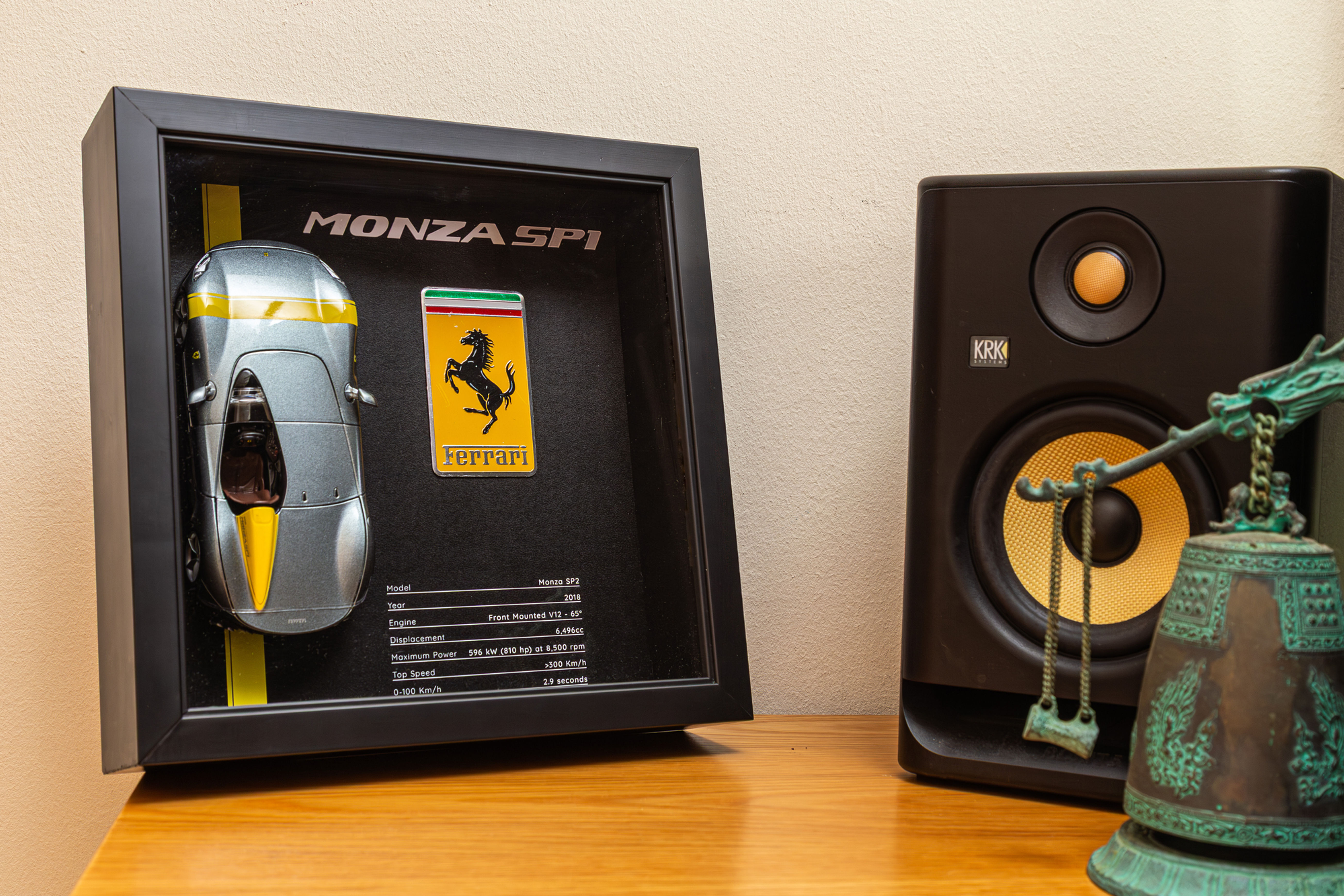 Framed Ferrari Monza SP1 Diorama featuring silver 1:24 scale model and large yellow Ferrari metal badge in black wood frame.