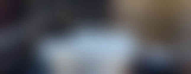 two white baths and a shower on outdoor decking beneath blue night sky with string of twinkly lights 