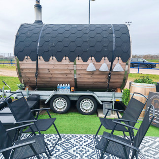 4 deck chairs situated next to a barrel sauna