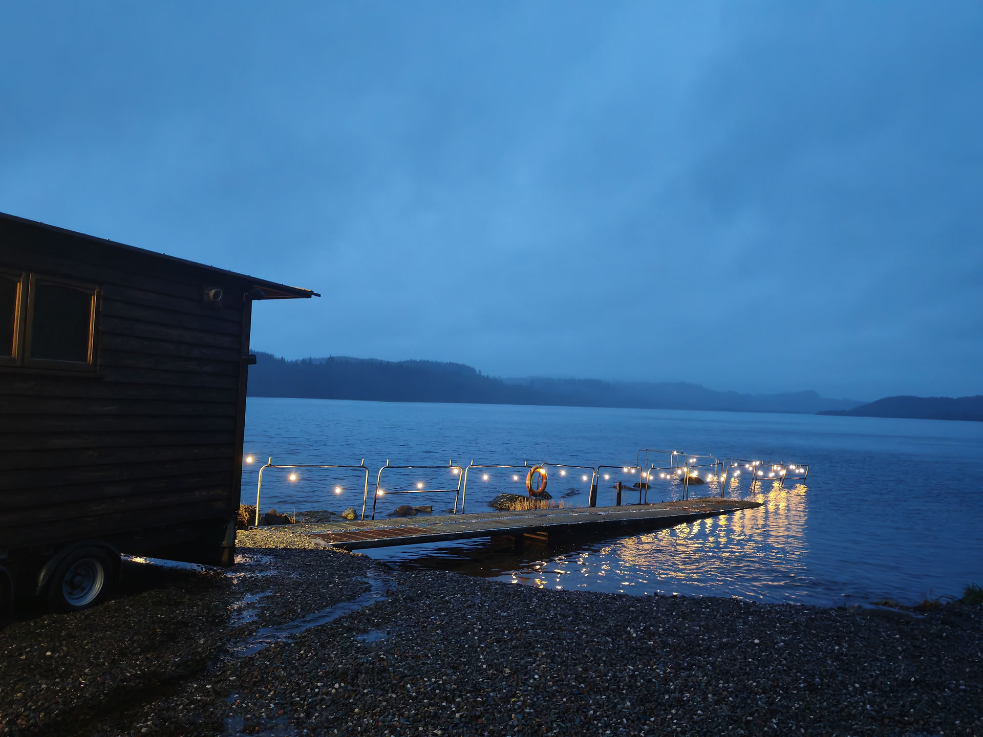 Lit up walkway into Loch Venacher, cloudy