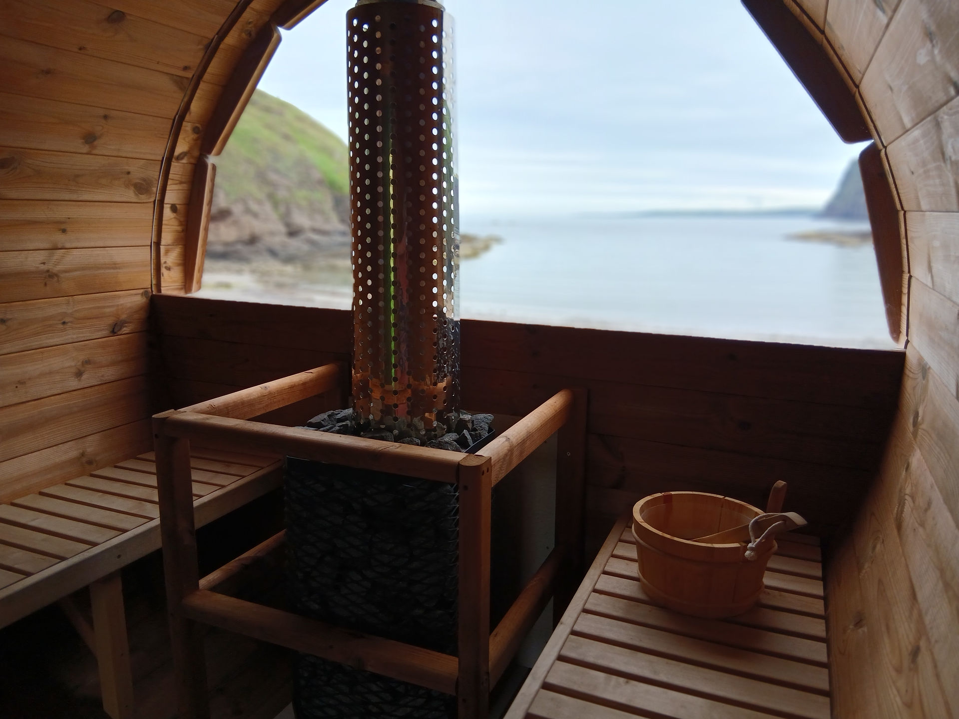 View out of sauna window with stove in foreground