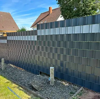Hochwertige Doppelstabmatten kaufen und montieren lassen: Fachgerecht einbetonierter Metallzaun in Frohnhofen. Diese schwere 8/6/8 Zaunanlage (1830 mm Höhe) in Anthrazitgrau bietet mit ihrem blickdichten, zweifarbigen PP-Sichtschutz und dem nach oben gerichteten Überstand maximale Sicherheit.
