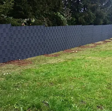 Fachgerecht montierter Doppelstabmattenzaun (8/6/8 mm) mit blickdichtem Premium-Sichtschutz in Vogelbach. Der 1830 mm hohe, anthrazitfarbene Zaun (RAL 7016) mit Abdeckleisten-Pfosten ist mit Schnellzement im Erdboden einbetoniert und mit 1,5 mm starken, gerillten Polypropylen-Streifen in Anthrazit ausgestattet.