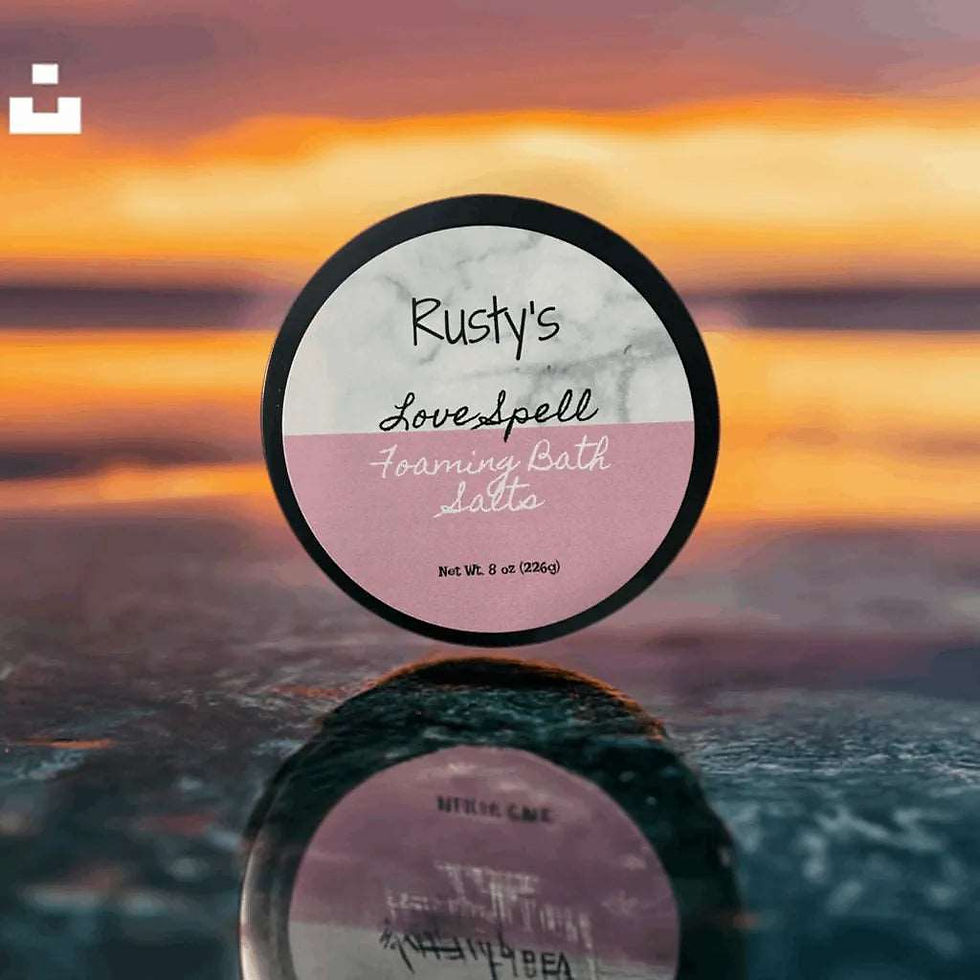 Thumbnail: Rusty's Foaming Bath Salts sit on a smooth rock, ready to provide a luxurious and relaxing bath experience. The salts are packaged in a sleek and modern container, perfect for any bathroom decor. Add these bath salts to your routine for a spa-like experience in the comfort of your own home.