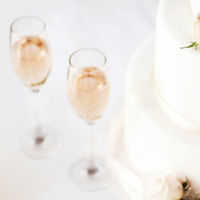 Wedding Cake And Champagne Flutes On Table