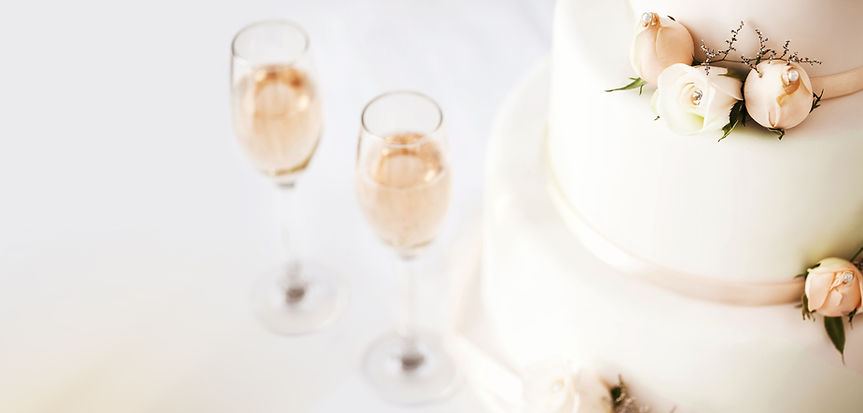 Wedding Cake And Champagne Flutes On Table