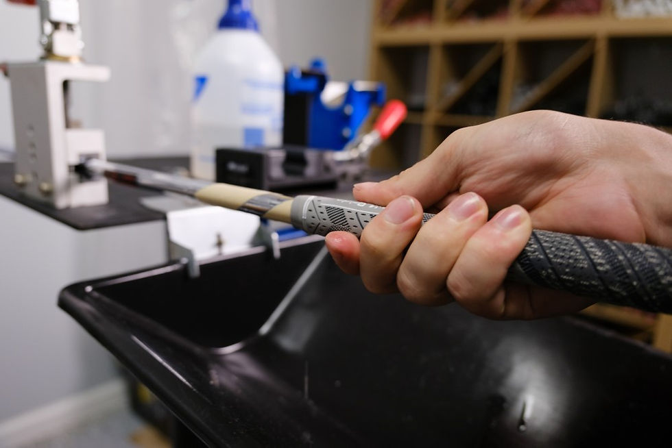 Golf club regrip station with a hand holding the golf grip