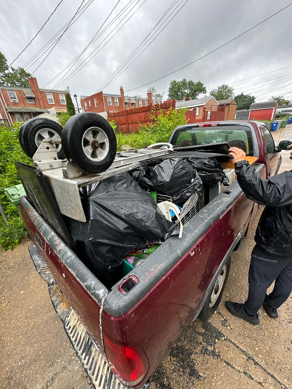 Eye-level view of a junk hauling truck parked outside a residential home