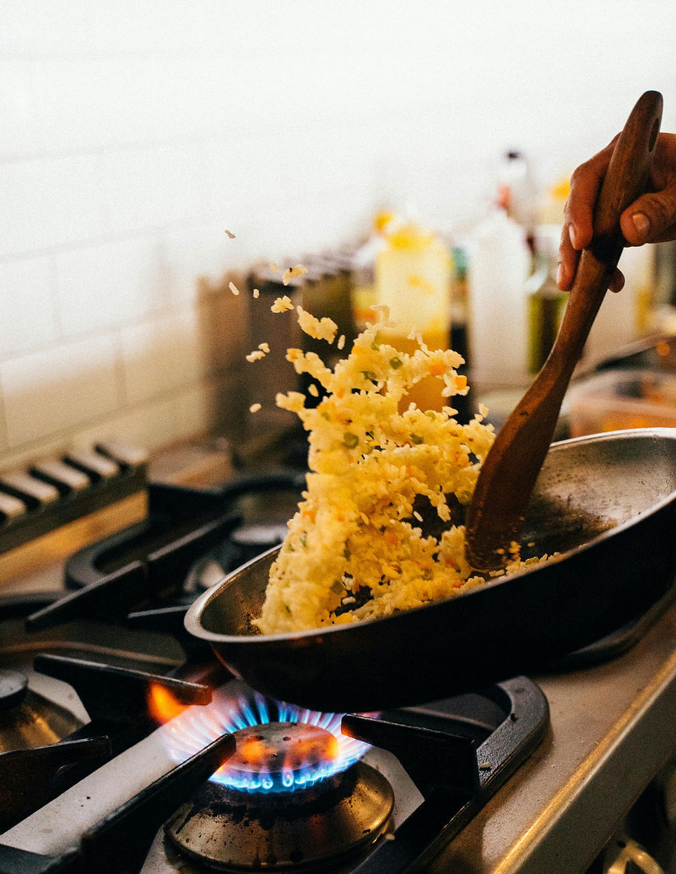 Person flipping and cooking rice over hot stove.