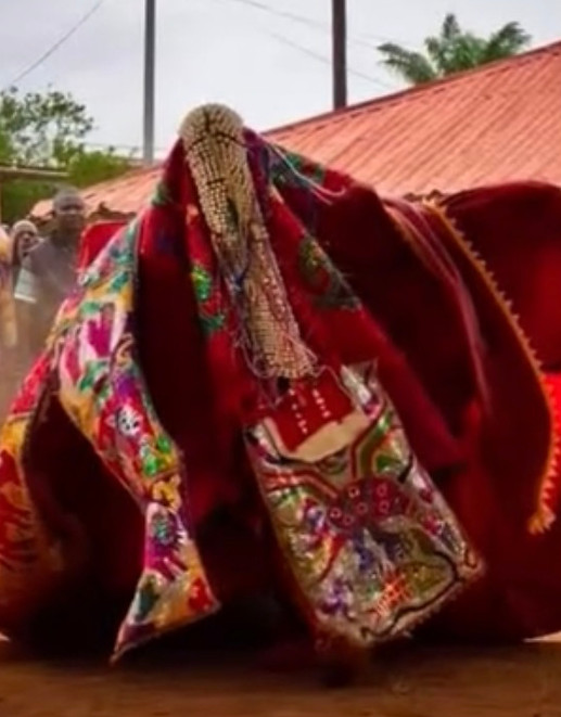 Voodoo performer in vibrant red and patterned costume in Ouidah Benin