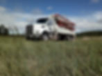 White concrete pump truck in a grassy field