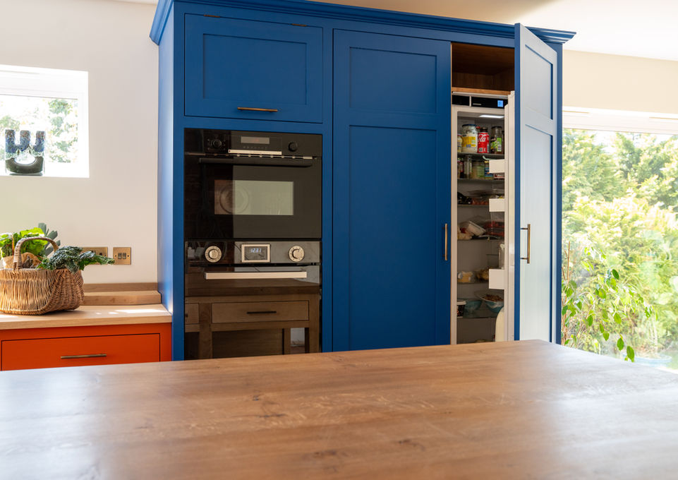 Hand crafted solid oak kitchen island. Hand painted blue kitchen cupboards. Bespoke luxury oak furniture. High end kitchen design.