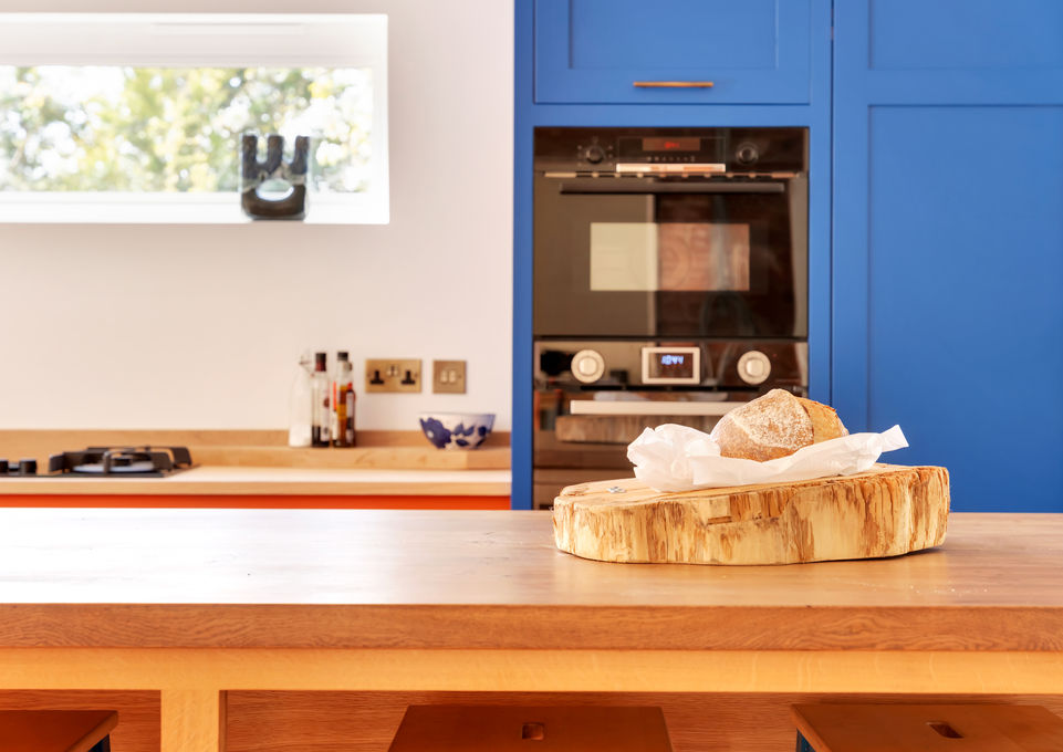 Hand crafted solid oak kitchen island. Hand painted blue kitchen cupboards. Bespoke luxury oak furniture. High end kitchen design.