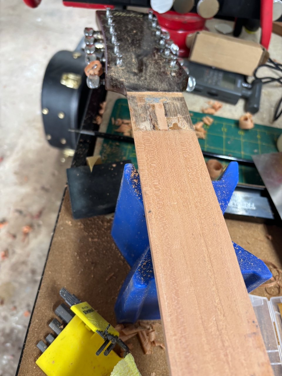 Full length mahogany shim installed (tapers to zero at nut end)