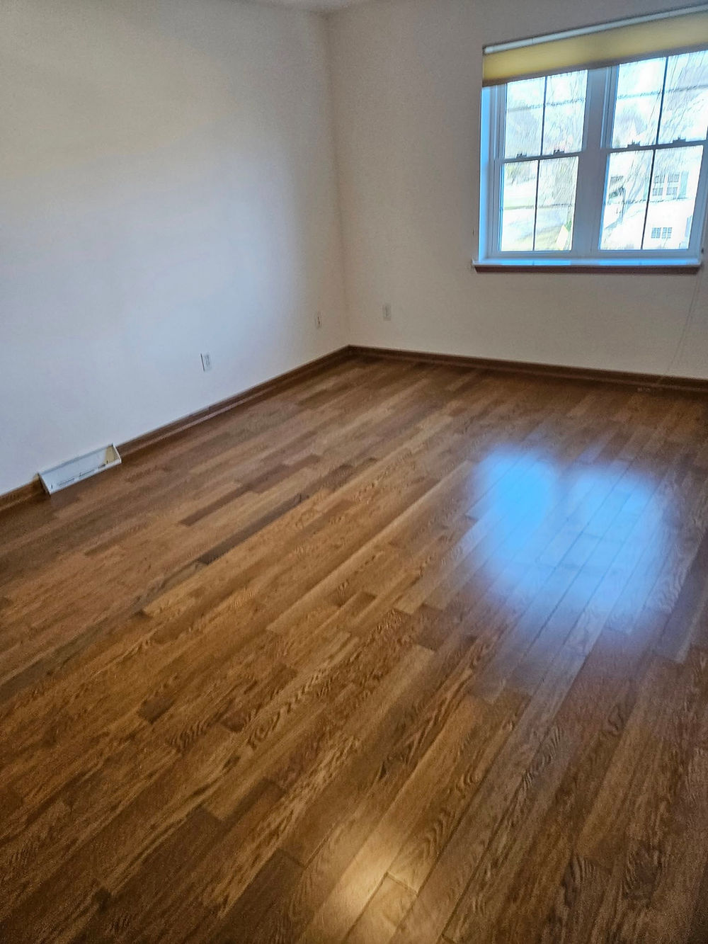 Clean room with polished wood floor by sparkly housekeepers llc