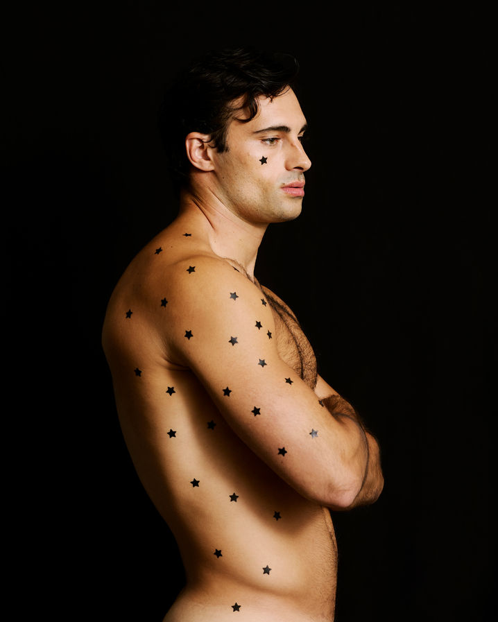 Model in editorial fashion ensemble leaning forward, dramatic lighting and styling by Ryan Blackwell