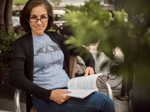 woman-wearing-a-tshirt-mockup-while-reading-a-book-with-glasses-at-a-park-a15864.png