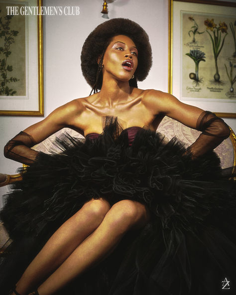 Woman in black tulle gown posing indoors with framed art in background.