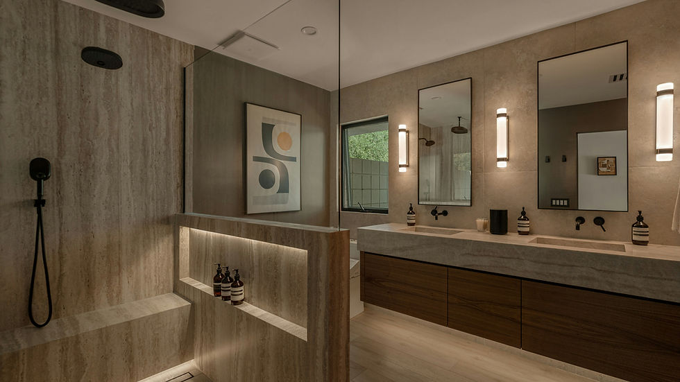 Close-up view of a zero-threshold walk-in shower with steam feature and natural stone tiles