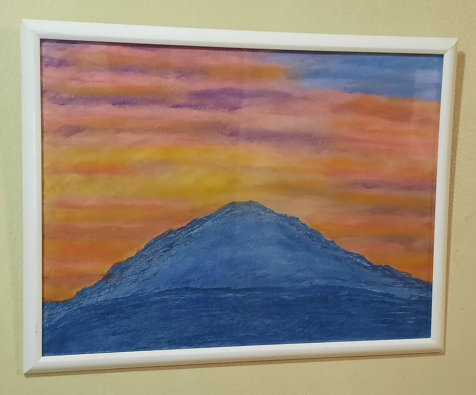 Wide angle view of a mountain range with a colorful sunset sky