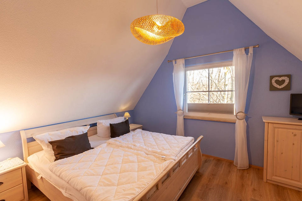 Ferienhaus Windsbraut Glowe auf Rügen - Schlafzimmer 1 im Obergeschoss mit 3 Betten und einem Zustellbett für Kleinkinder