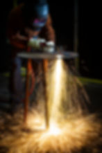 Sparks flying as Cadent Gas engineer cuts metal with a welding torch in a Birmingham workshop.