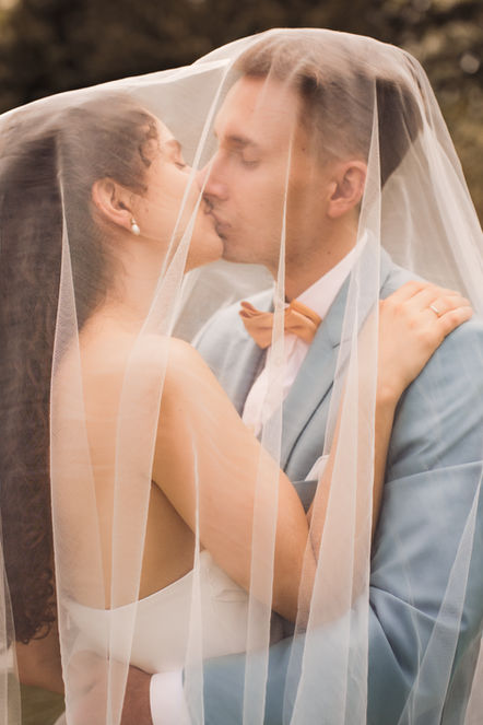 Hochzeitspaar küsst sich unter dem Schleier, Frühlingshochzeit