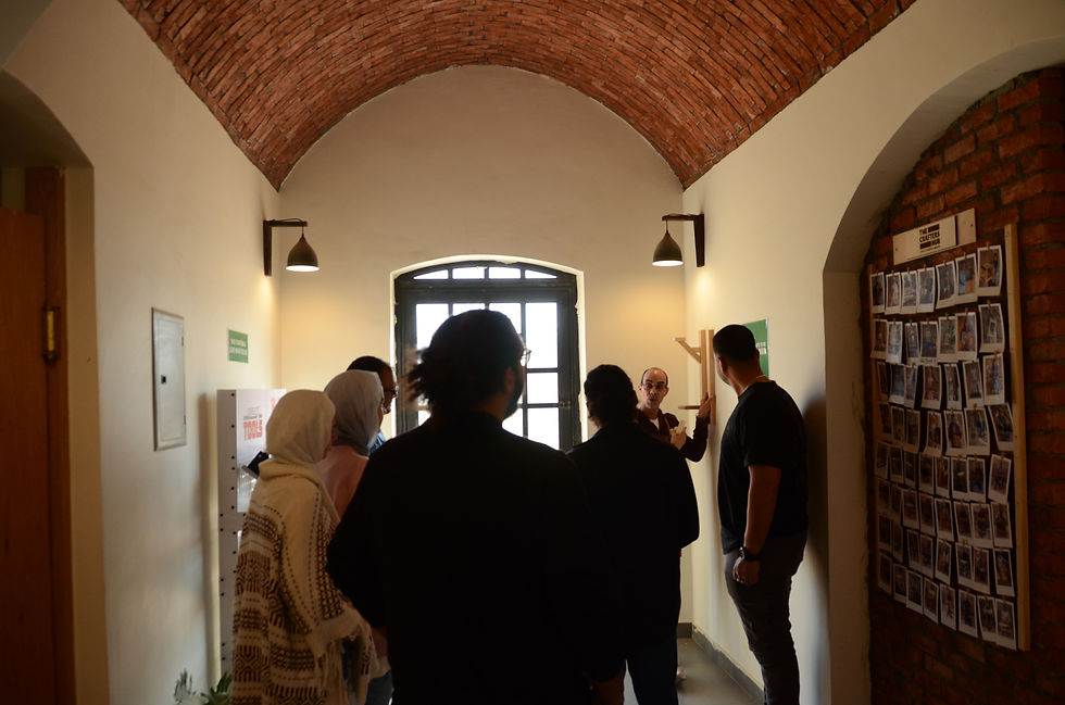 People gather in a brick hallway, learning woodcraft