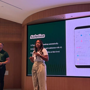 Keila Doyle presenting the Golf Hero pitch deck at a live event in Dubai, with the app's Solution slide displayed on screen behind her