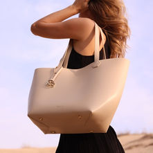 Vogaya structured bambote bamboo leather tote bag in sand leather tones against a Dubai desert sky