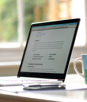 Laptop showing IB essay writing and editing services, helping students worldwide with personalized college and IB tutoring support