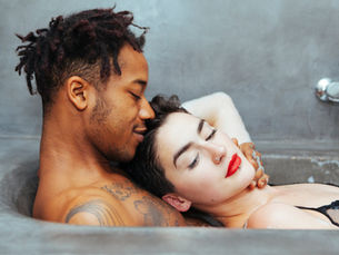 an interracial couple sharing an intimate in the bathtub