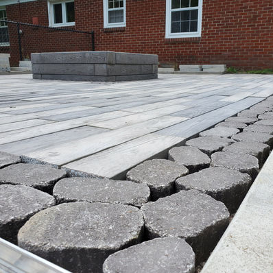 A lush green lawn scattered with colorful flowers and smooth rocks, creating a vibrant outdoor landscape.