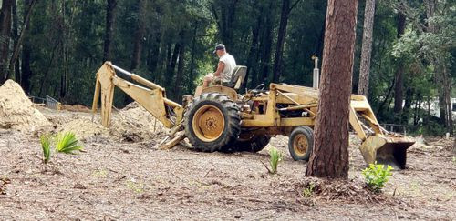man on backhoe digging trenches
