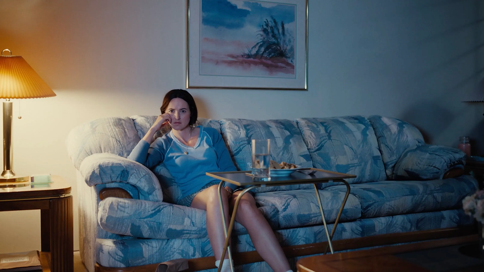 Scene from The Backrooms where Mary is sitting on her 90s couch watching TV