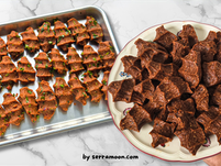 Two plates of Turkish çiğ köfte; one metal with parsley garnish, the other ceramic with plain köfte. Marble background, "by serramoon.com" text.