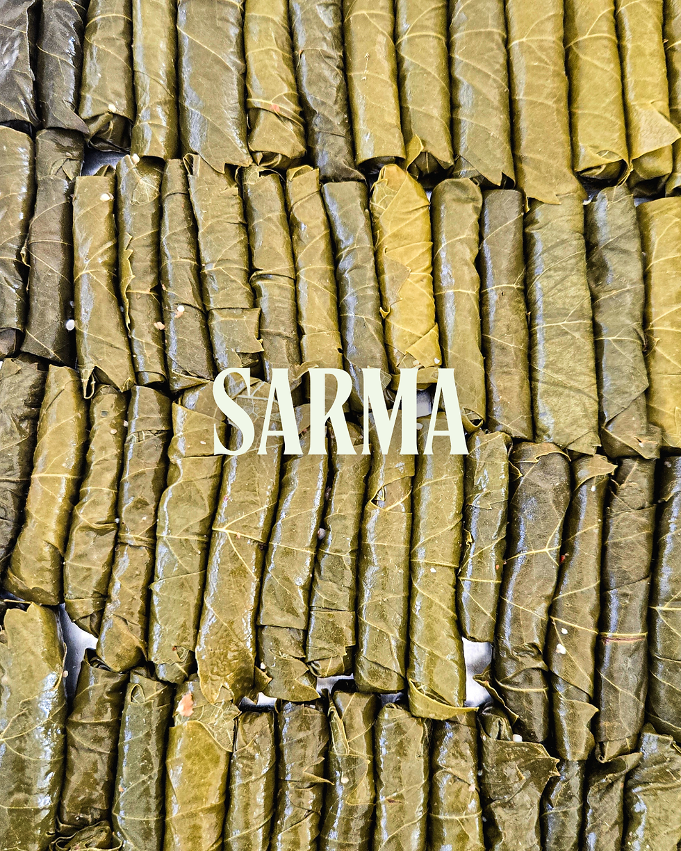 Rows of green grape leaf wraps, known as Sarma, with a text overlay in white. The mood is neat and organized.