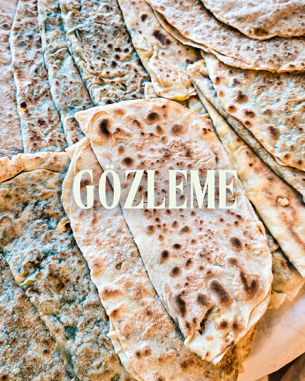 Gözleme layers fill the image, showcasing golden brown, textured flatbreads. The word "GOZLEME" is prominently printed on top.