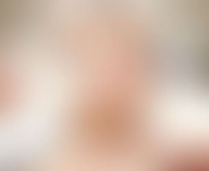 Woman receiving facial treatments with various beauty tools in a spa setting. Calm expression, white headband, light background.