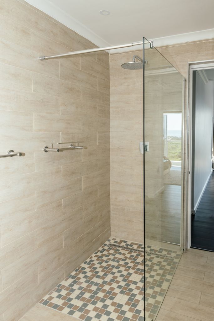 Modern walk-in shower with glass screen and mosaic tiles
