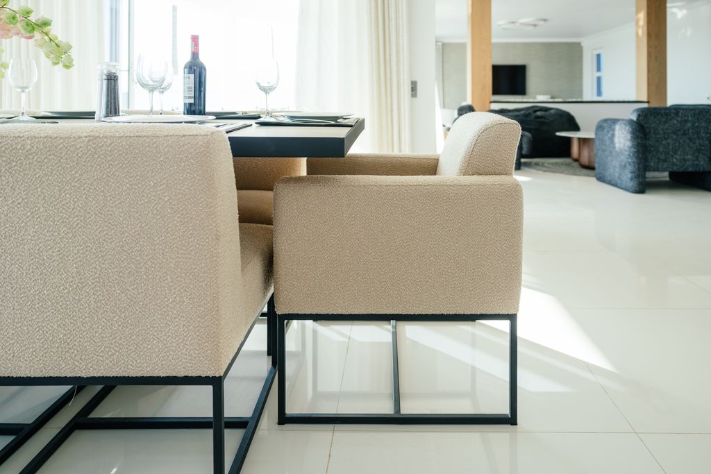 Beige boucle dining armchairs with black metal frames