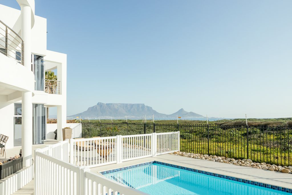 Swimming pool at a white villa with Table Mountain view
