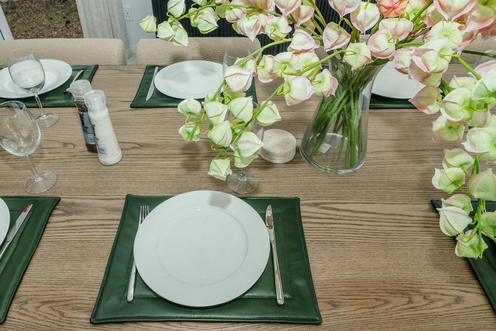 Dining table set with green placemats and floral centerpiece