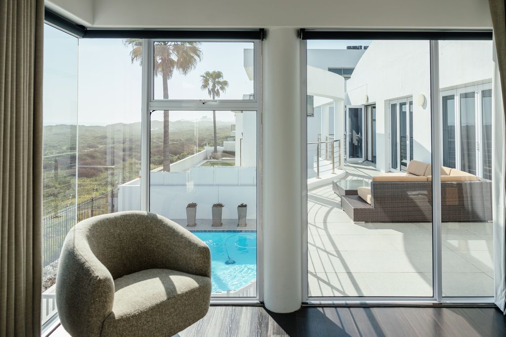 Modern room view of a patio with pool and palm trees