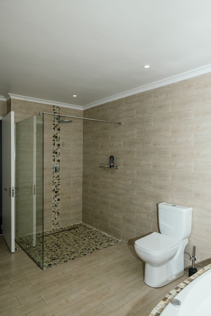 Modern bathroom with walk-in glass shower and white toilet
