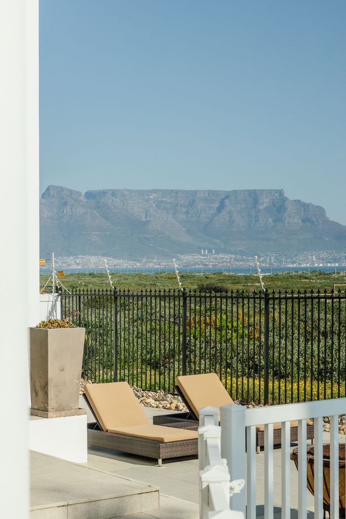 View of Table Mountain from a patio with lounge chairs.